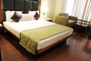 una habitación de hotel con una cama grande y una silla en CALISTA RESORT en Nueva Delhi