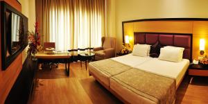 Habitación de hotel con cama y escritorio en CALISTA RESORT, en Nueva Delhi