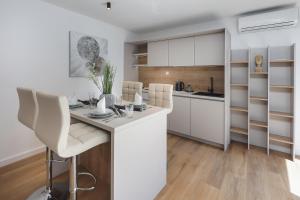 a kitchen with white cabinets and a table and chairs at Residence INN Rijeka in Rijeka