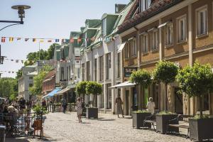 a street with people walking down a street with buildings at Stor modern villa med toppläge! in Kalmar