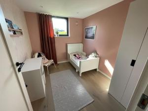 a small room with a crib and a childs bedroom at Stor modern villa med toppläge! in Kalmar