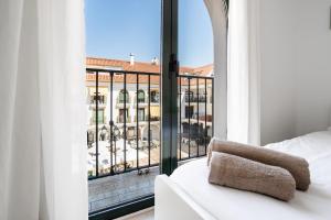 a bedroom with a view of a building from a window at Sur Suites Los Patios in Fuengirola
