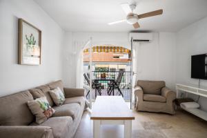 uma sala de estar com um sofá e uma mesa em Sur Suites Los Patios em Fuengirola