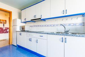 a white kitchen with a sink and a refrigerator at A&N Villa Catiana in Torre del Mar