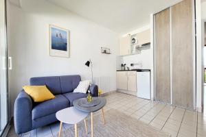 a living room with a blue couch and a table at App. Résidence Parking Belle Terrasse Proche Port in Vannes