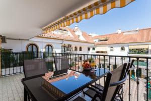 a balcony of a house with a table and chairs at Sur Suites Los Patios in Fuengirola