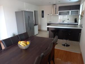 a kitchen with a table with a bowl of bananas on it at Apartment Kućica in Zadar