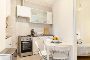 uma pequena cozinha com uma pequena mesa e cadeiras num quarto em Relax in Lisbon for 4 people with terrace and parking em Lisboa