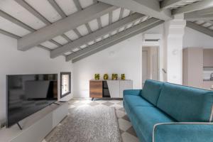 チッタデッラにあるCorte alle mura - Mansarda luxのリビングルーム(青いソファ、テレビ付)