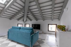 チッタデッラにあるCorte alle mura - Mansarda luxのリビングルーム(青いソファ、テレビ付)