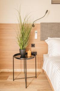 un tavolo con una pianta accanto a un letto di Privilege Suit SLiema a Sliema