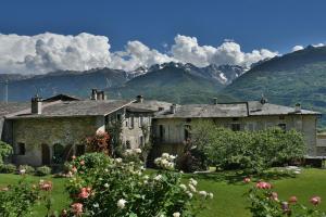 an old stone house with mountains in the background at Il Drago al Roseto del Drago in San Bernardo