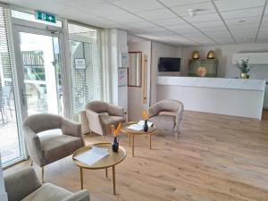 une salle d'attente avec des chaises et des tables dans un hôpital dans l'établissement Seehotel Oostkapelle, à Oostkapelle