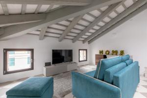 un soggiorno con sedie blu e TV a schermo piatto di Corte alle mura - Mansarda lux a Cittadella