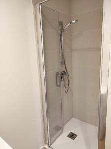 La salle de bains est pourvue d'une douche avec une porte en verre. dans l'établissement T2 hyper centre LONS LE SAUNIER, à Lons-le-Saunier