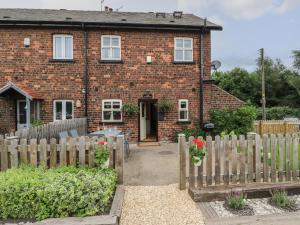 a brick house with a wooden fence in front of it at The Moorings in Wakefield