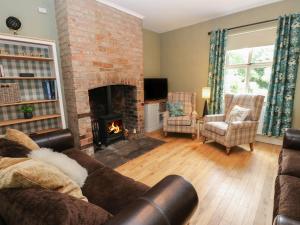 a living room with a couch and a fireplace at The Moorings in Wakefield