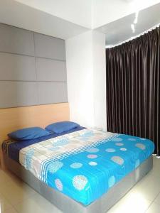 1 dormitorio con 1 cama con edredón azul en Ryan dan Ilham Apartemen, en Dadap