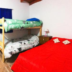 a bedroom with two bunk beds and a red bed at Alojamiento Gonzalez Paz in Puerto Madryn