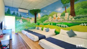 恆春的住宿－迎薰旅店，卧室配有三张床,墙上挂有壁画