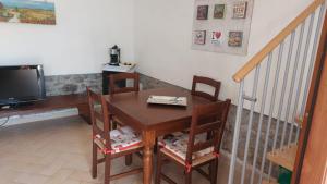 a dining room table with chairs and a television at il Fienile di Penelope in Marliana