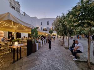 a group of people sitting at tables in a street at La Casa di Mimi in Monopoli