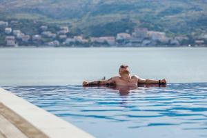 a woman floating in a body of water at Hotel Plaza in Pag
