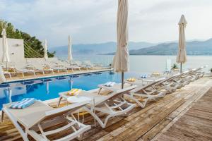 a row of lounge chairs next to a swimming pool at Hotel Plaza in Pag