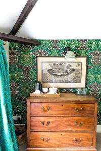 un tocador en una habitación con una pared cubierta de flores en Tickton Grange Hotel, en Beverley