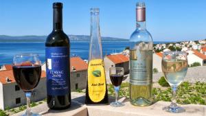 three bottles of wine sitting on a table with glasses at Villa Ana in Bol