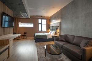 - un salon avec un canapé et un lit dans l'établissement Quality Hotel Richard With, à Stokmarknes