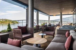 a patio with couches and tables and a view of the water at Quality Hotel Richard With in Stokmarknes