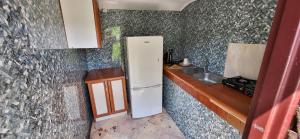 a small kitchen with a refrigerator and a sink at Altana letnia nr2 - Herbergerówka Agroturystyka na wsi in Stosrow