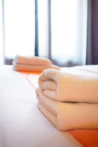 un mucchio di asciugamani seduti sopra un letto di Hotel restaurant le top du Roulier a Capendu
