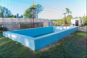 uma grande piscina azul sentada na relva em Inno Farms em Kharar
