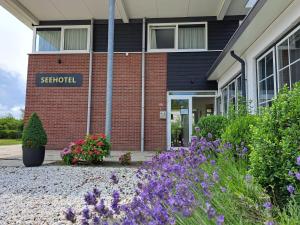 ein Schulgebäude mit Blumen davor in der Unterkunft Seehotel Oostkapelle in Oostkapelle