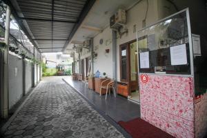 un pasillo vacío de un edificio con una mesa en Capital O 2258 Santana Syariah Guest House en Solo