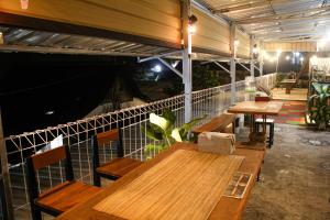a group of wooden tables and benches in a restaurant at Capital O 2258 Santana Syariah Guest House in Solo