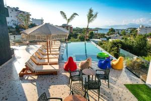 un patio con sillas y una piscina en Sunlight Hotel, en Ksamil