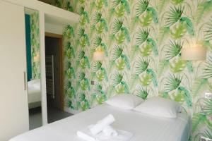 ein Schlafzimmer mit einem Bett mit einer tropischen Tapete in der Unterkunft Stunning air-conditioned villa "Ronsard" with swimming pool in Saint-Aygulf