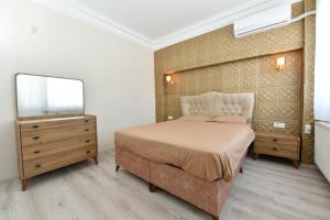 a bedroom with a bed and a dresser and a mirror at Dubleks Suite 4-1 in Istanbul
