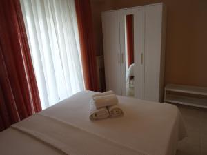 a bedroom with two towels on a bed with a window at JOY's Central Apartment in Thessaloniki