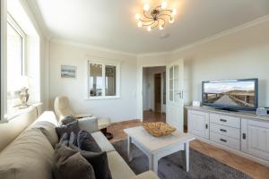 ein Wohnzimmer mit Couch und Flachbildfernseher in der Unterkunft Appartement Kleeblatt in Westerland