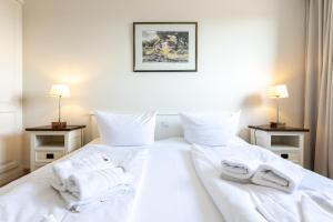 een slaapkamer met 2 witte handdoeken op een bed bij Appartement Kleeblatt in Westerland
