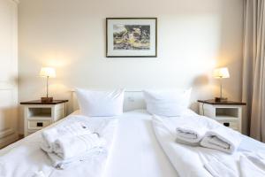ein Schlafzimmer mit zwei weißen Handtüchern auf einem Bett in der Unterkunft Appartement Kleeblatt in Westerland