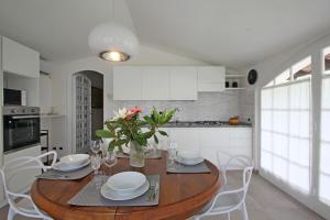 - une cuisine avec une table en bois et des placards blancs dans l'établissement Villa Fabiana, à Nicola