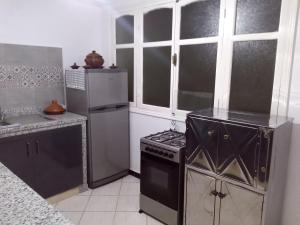 a kitchen with a stove and a refrigerator at Appartement in Agadir