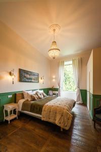 sypialnia z dużym łóżkiem i żyrandolem w obiekcie Manoir de Laroque Delprat w mieście Autoire