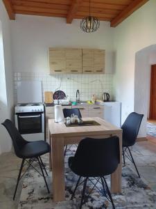 uma cozinha com uma mesa de madeira e cadeiras em OLD HOUSE em Jajce