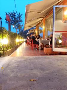 un groupe de personnes assises dans un restaurant la nuit dans l'établissement San Quirico Locanda ristorante pizzeria, à Barbarasco